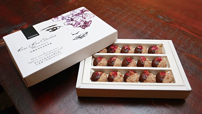 盒裝的玫瑰卡馬龍，送禮自用兩相宜，椰子自然溫和的甜味，不論受贈者是否嗜吃甜食都能接受。包裝盒上優雅的畫作是藝術家黃莞淑的作品。