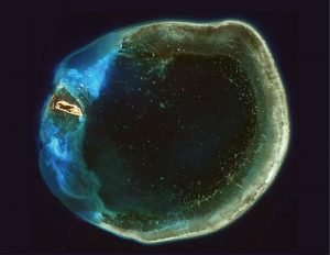 自太空拍攝的東沙環礁群島，宛如美麗的指環。可惜漁業經費少，執法稽查人力不足，環境因中國漁船盜採破壞嚴重。（圖片來源：海管處）